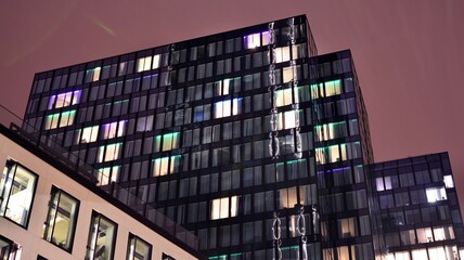 Office building at night, building facade with glass and lights. View with illuminated modern skyscraper. © Grand Warszawski