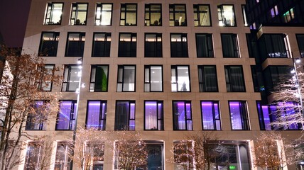Office building at night, building facade with glass and lights. View with illuminated modern...