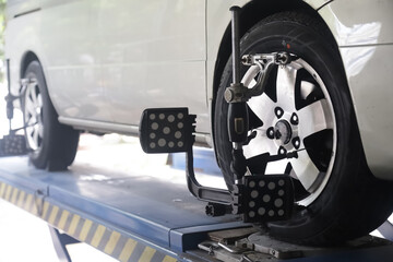 Mechanic installs sensor for wheel alignment job in repair shop.balancing wheel with aligner