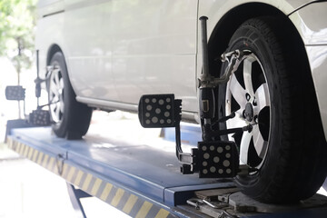 Mechanic installs sensor for wheel alignment job in repair shop.balancing wheel with aligner