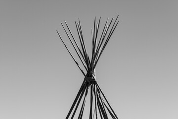 Teepee sticks with clear sky in black and white.