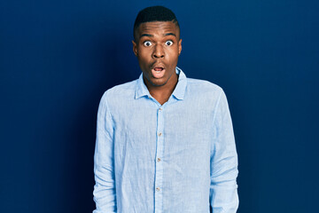 Obraz premium Young african american man wearing casual clothes afraid and shocked with surprise expression, fear and excited face.