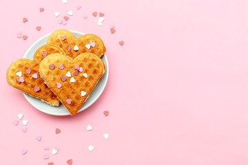 Homemade Belgian waffles heart shaped on plate with colorful sweet mini confetti, sprinkles food. pink background for Valentines day, womens day, love, romance, party pattern with copy space - obrazy, fototapety, plakaty