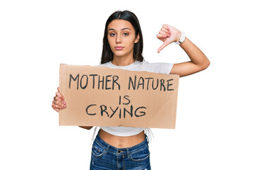 Young hispanic girl holding mother nature is crying protest cardboard banner with angry face,...