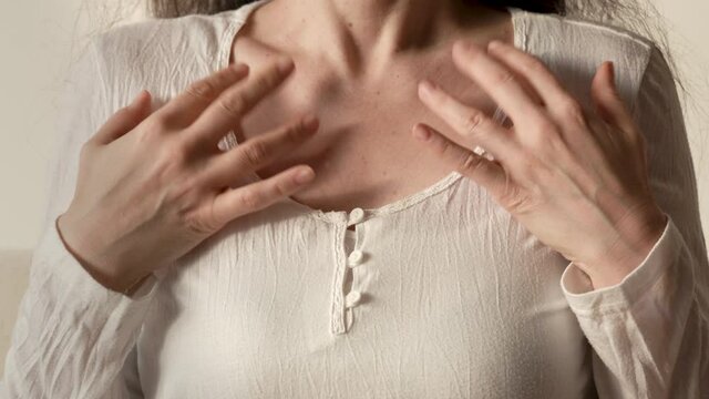Woman in white shirt practicing EFT or emotional freedom technique - tapping on the collarbone point