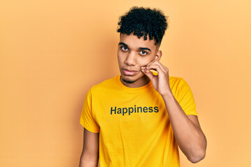 Young african american man wearing t shirt with happiness word message mouth and lips shut as zip...