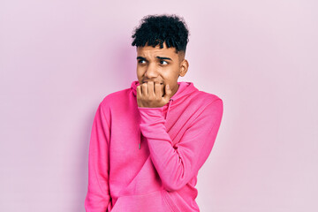 Fototapeta na wymiar Young african american man wearing casual sweatshirt looking stressed and nervous with hands on mouth biting nails. anxiety problem.