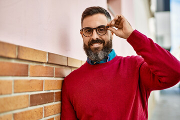 Young hispanic executive man smiling happy standing at the city.