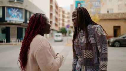 Two african american friends smiling confident standing together speaking at street