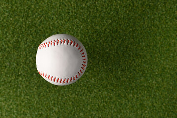 White baseball ball on a green sports field. Minimalism. There are no people in the photo. Abstraction. Professional and amateur sports, sports games, outdoor activities, training.