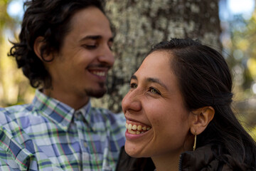 Fototapeta premium Young latin couple (28) smile happily. Selective focus on the woman's face. Valentine's Day concept, couples and friendships.