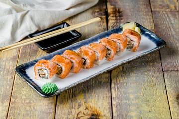 Philadelphia roll with eel and fried salmon on wooden table