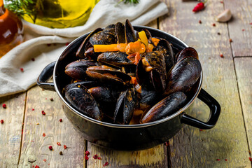 Mussels in tomato sauce on wooden table