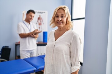 Middle age man and woman physiotherapist and patient having rehab session at physiotherapy clinic