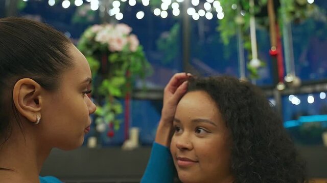 Close-up portrait of young beautiful girls lespians couple hugging and dancing a pair dance. The the girl corrects and gently touches her girlfriend's hair. The concept of love, relationship, meeting.