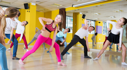 Group of tweens exercising with female coach in choreography class