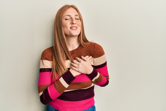Young irish woman wearing casual clothes smiling with hands on chest with closed eyes and grateful gesture on face. health concept.