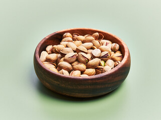  Bowl of pistachios over green background