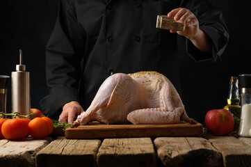 Raw turkey carcass, chicken lies on a wooden cutting board. Ingredients. The chef sprinkles the poultry with spices. Cooking poultry dishes. A festive dish. Restaurant, hotel, culinary blog.