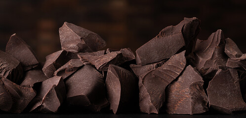 pieces chocolate on dark background. pile of sweet food