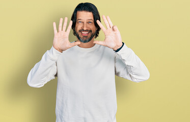 Middle age caucasian man wearing casual clothes showing and pointing up with fingers number nine...