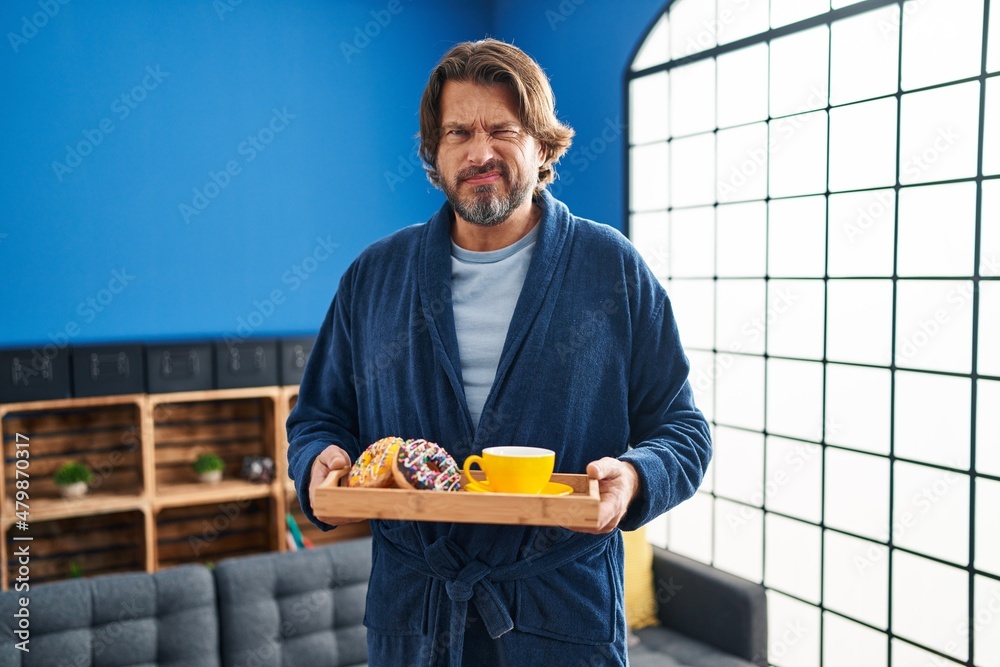 Canvas Prints Handsome middle age man holding tray with breakfast food skeptic and nervous, frowning upset because of problem. negative person.