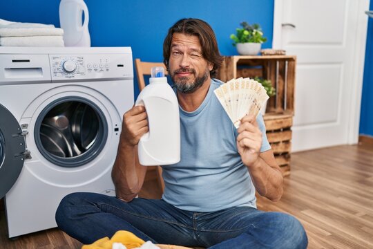 Handsome middle age man saving money of laundry detergent skeptic and nervous, frowning upset because of problem. negative person.