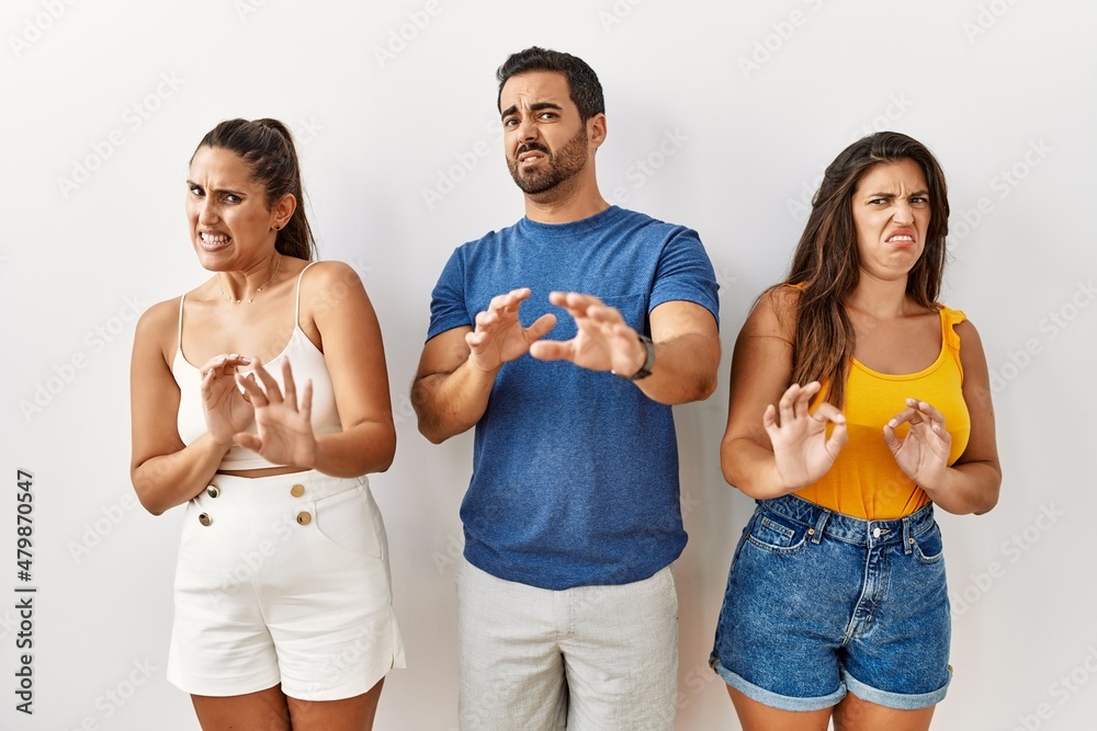 Wall mural group of young hispanic people standing over isolated background disgusted expression, displeased an