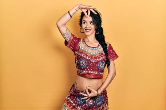 Young indian woman wearing traditional belly dancer costume. Dancing exotic oriental dance with body and hands