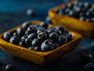 Many fresh blueberries in bowls on a blue background. Vitamin product, antioxidants, healthy food. Juices, juices, pie fillings, sauces. Delicious healthy breakfast.