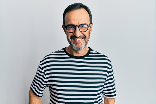 Middle age hispanic man wearing casual clothes and glasses with a happy and cool smile on face. lucky person.