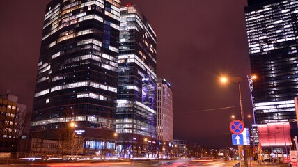 Amazing night cityscape. Office building at night, building facade with glass and lights. View with illuminated modern skyscraper. Scenic glowing windows of skyscrapers at evening.  © Grand Warszawski