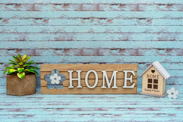 Wooden letters Home. Model of a wooden house. Buying or renting a home. Environmentally friendly product. Blue wooden background. Board with text.