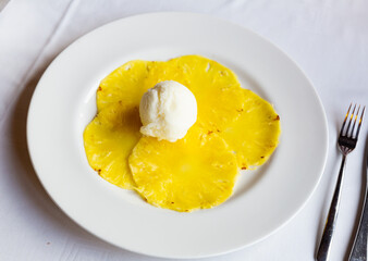 Fruit dessert. Sweet carpaccio of ripe pineapple with scoop of creamy lemon ice cream.