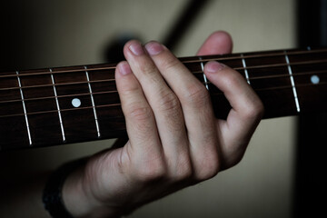 Hand playing masterly on a guitar.