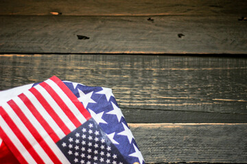 American flag on a black wooden floor illuminated from behind.