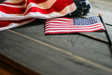 American flag on a black wooden floor illuminated from behind.