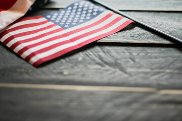 American flag on a black wooden floor illuminated from behind.