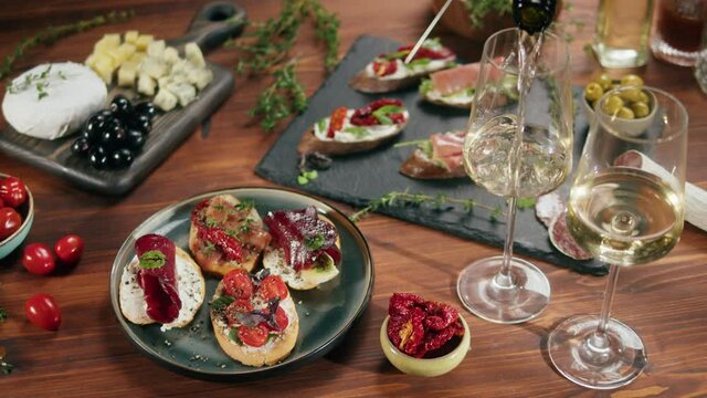 Italian restaurant with traditional food, Spanish cuisine, delicious tapas and white wine, bruschetta with cheese, olives dry tomatoes and tasty sandwich bar appetizer, buffet high cuisine table