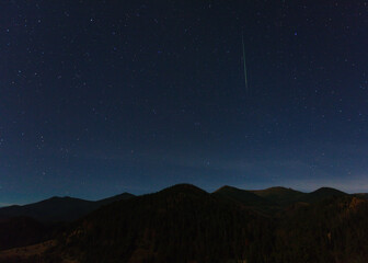 Carpathian mountains at night with shooting star