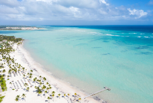 Juanillo beach with palm trees, white sand and turquoise caribbean sea. Cap Cana is a tourist area in Dominican Republic. Aerial view