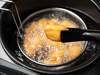 Cooking tempura chicken nuggets in deep fryer