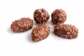 Chocolate candies with hazelnut crumbs on an isolated white background. 