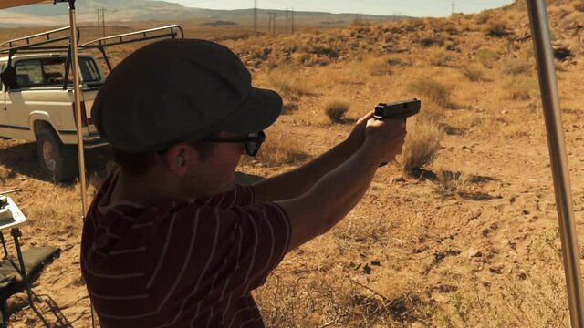 Close up view of a man shooting a strong shot with his gun with recoil in a shooting range in Pleasant Valley, California,USA on 4th July.