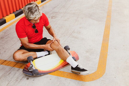 Accident during outdoor skateboarding : Young man with knee pain slips on  the road, sits on the floor showing pain after his knee hits the ground.  Stock Photo | Adobe Stock