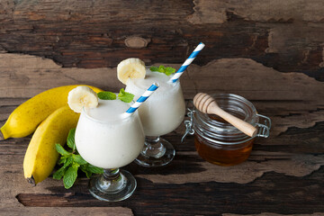 Banana fresh cocktail vanilla smoothies  fruit juice beverage healthy the taste yummy in glass drink episode good morning on wooden background from the top view.
