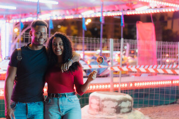 Young smiling couple having a ride on a amusement park. Couple Dating Amusement Park Enjoyment of the fair.