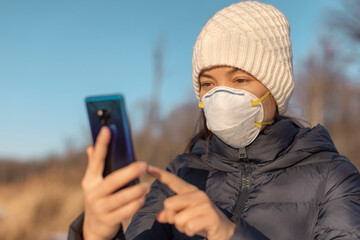 N95 mask Asian woman wearing mouth cover on face walking outside during coronavirus pandemic using...