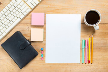 Empty paper with pencil and pen with coffee cup on wooden desk