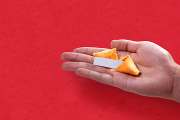 Fortune cookies with an empty quote on a human hand with a colored background
